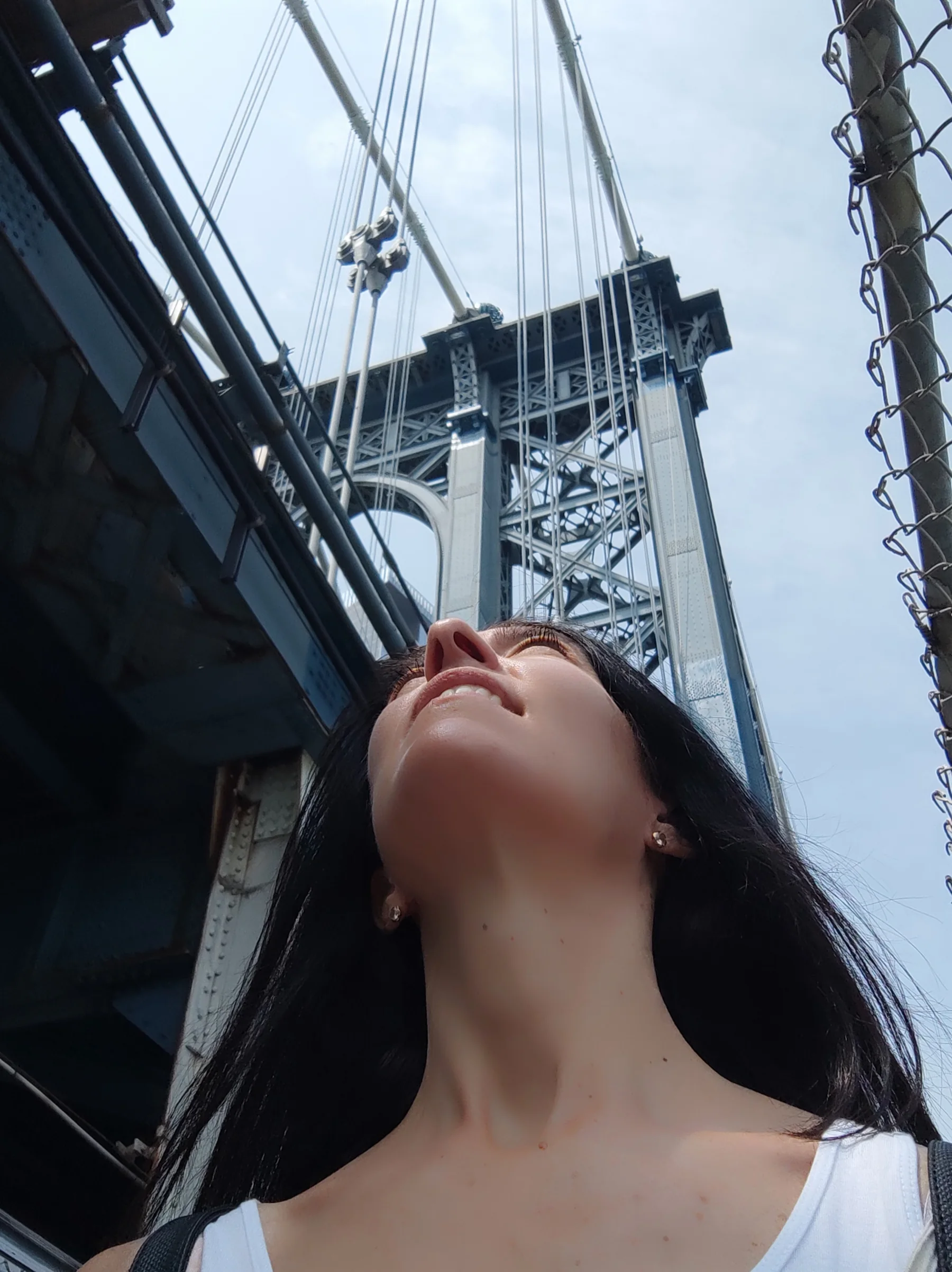 Silvia mirando los cables y la torre de un puente colgante